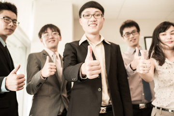 Business team holding their thumbs up