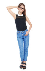 Young fashion girl in jeans and glasses posing isolated