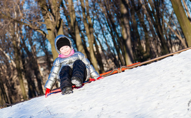 Fototapeta na wymiar Little girl playing outdoors in winter