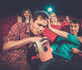 Impudent young man steals popcorn in cinema 