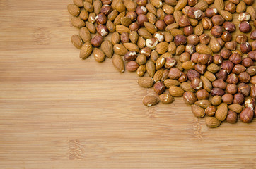 mix of almonds and hazelnuts in the corner of a wooden table