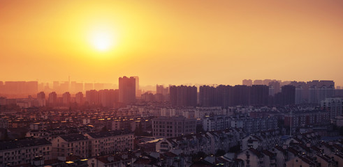 Naklejka na ściany i meble Bright colorful sunrise over big city panorama. Vintage toned