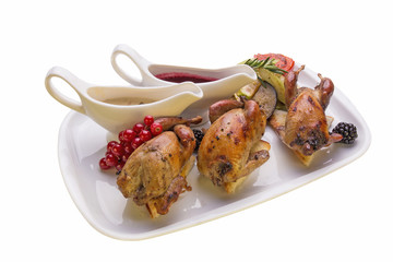 Roasted quail with vegetables on white background
