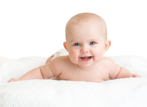 Cute smiling baby lying on white towel