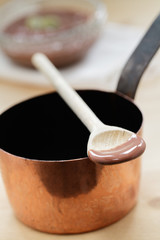 Holzlöffel mit Schokolade auf Kupfertopf