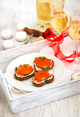 Fototapeta na wymiar Heart shaped toasts with red caviar and white wine
