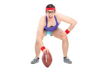 Young sportsman posing with a football