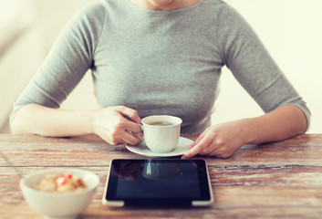 woman drinking coffee and using tablet pc