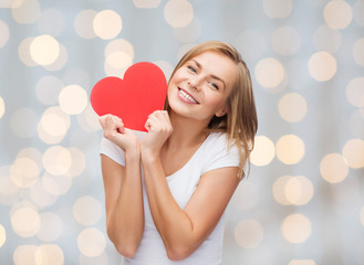 smiling woman in white t-shirt holding red heart