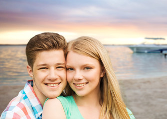 Fototapeta na wymiar smiling couple hugging over beach background