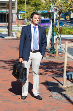 smiling successful business man walking outside down the street