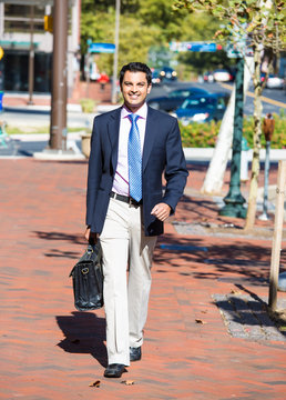 smiling happy successful business man walking on a street