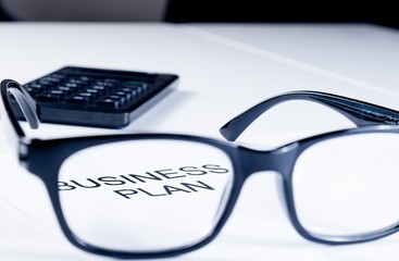 business plan words see through glasses lens near calculator