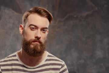 Young creative man posing on dark background
