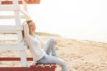Young woman sitting on beach lifeguard chair