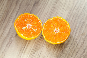 Organic orange fruit. Slices on wooden background