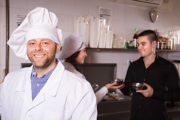 Male waiter holding dishes at kitchen