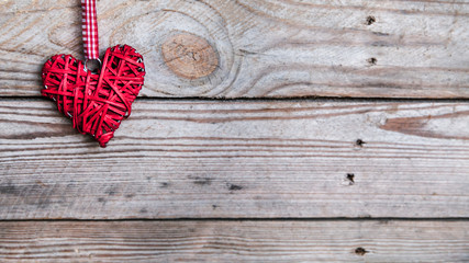Red heart on a wooden background.