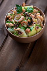 Italian octopus salad with potato and parsley in a glass bowl