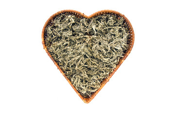 dry Absinth wormwood medical herbs in heart form basket isolated