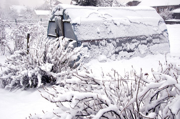 snowy plastic greenhouse hothouse in midwinter  garden