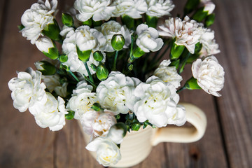delicate bouquet of carnations in vintage vase with heart
