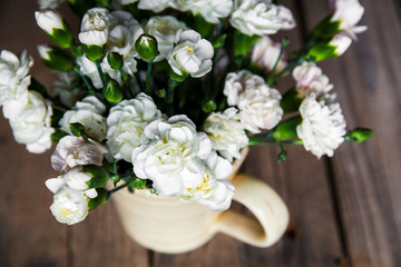 delicate bouquet of carnations in vintage vase with heart