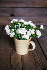 Fototapeta na wymiar delicate bouquet of carnations in vintage vase with heart