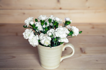 delicate bouquet of carnations in vintage vase with heart