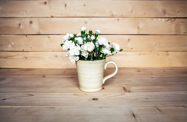 delicate bouquet of carnations in vintage vase with heart