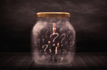 Businessman locked into a jar with question marks concept