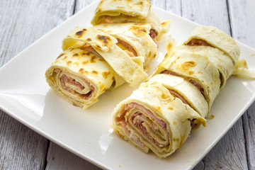 Roll of piadina with ham and cheese