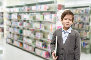 Little boy holding a book in the library