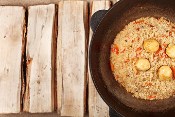 traditional central asia pilaf in kazan on logs