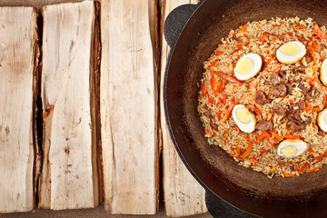 traditional central asia pilaf in kazan on logs