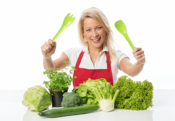 Blonde Hausfrau mit Schürze präsentiert Gemüsesorten