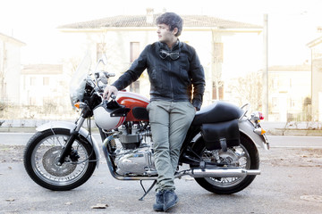 Fototapeta na wymiar young biker relaxing leaning your motorcycle