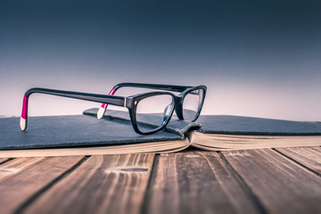 Brille auf aufgeschlagenem Buch