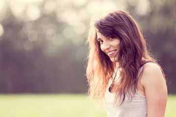 Naklejka premium Beauiful young smiling girl with dark hair in the garden