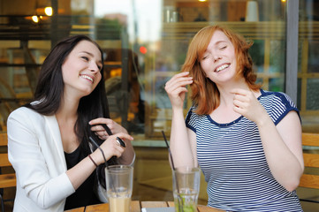 Two young woman at the outdoors cafe