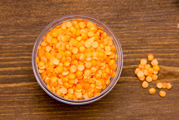 Red lentils on bowl on wooden table top views