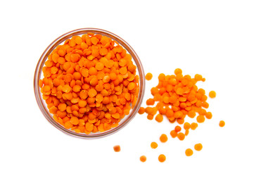 Red lentils on bowl on white background viewed from above