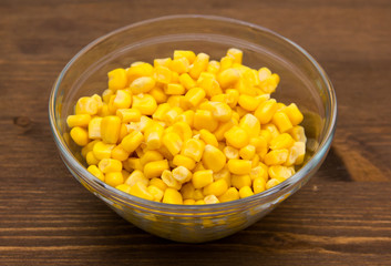 Sweet corn on glass bowl on wooden table