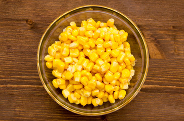 Sweetcorn on bowl on wooden table seen from above
