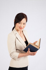 Asian woman with a book smiling