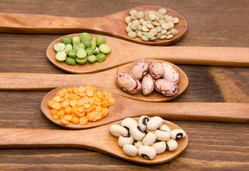 Vegetables on wooden spoons on wooden table