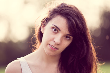 Naklejka premium Beautful young woman looking at you in the garden