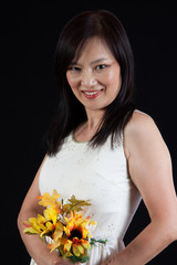 Asian woman with flowers, smiling at the camera