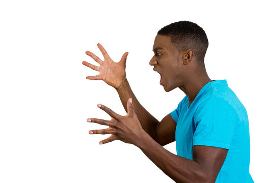  angry upset young man fists in air, open mouth yelling