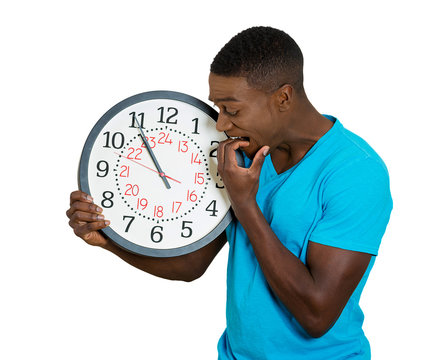man with clock stressed biting fingernails pressured by time